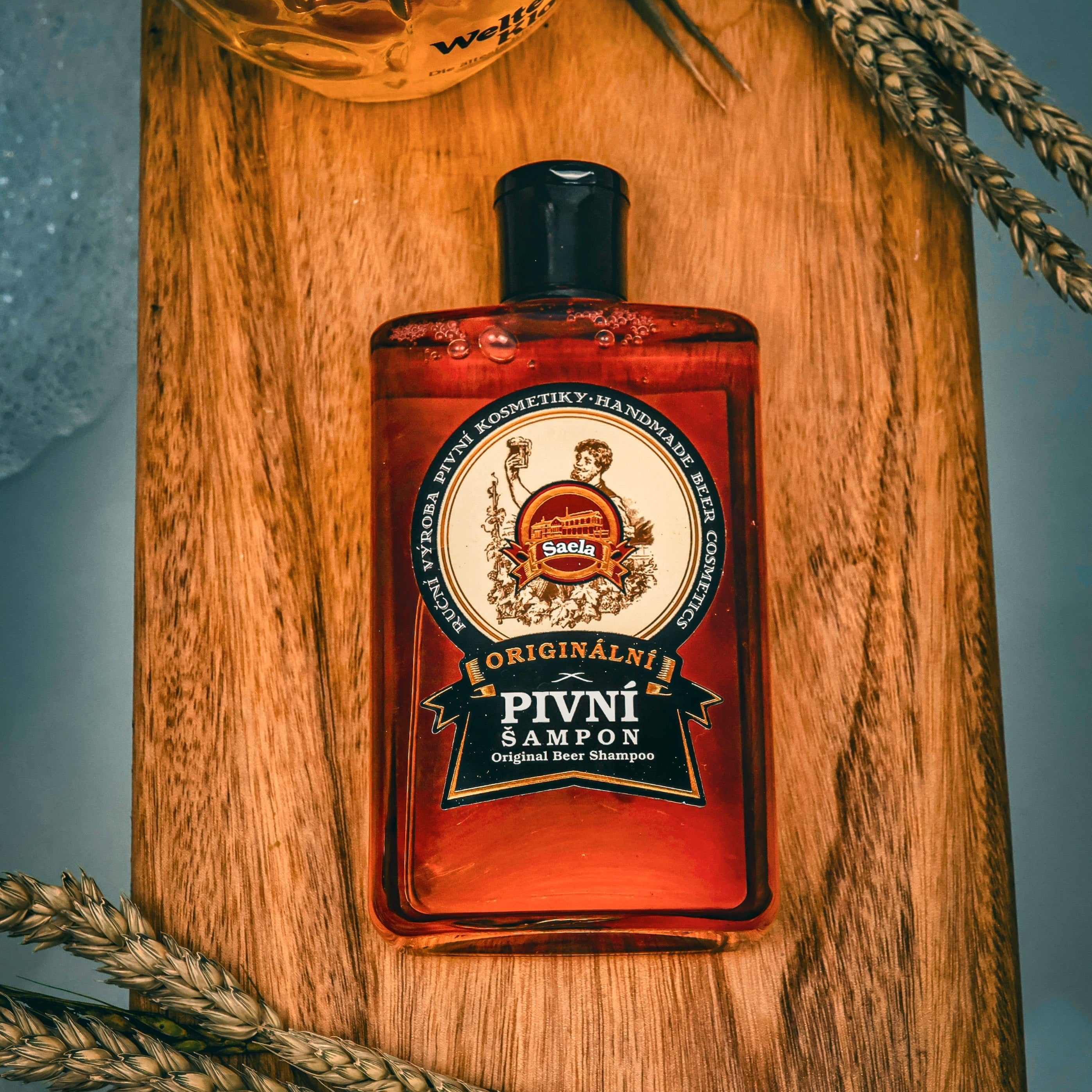 Red bottle with a label on a wooden surface with wheat stalks